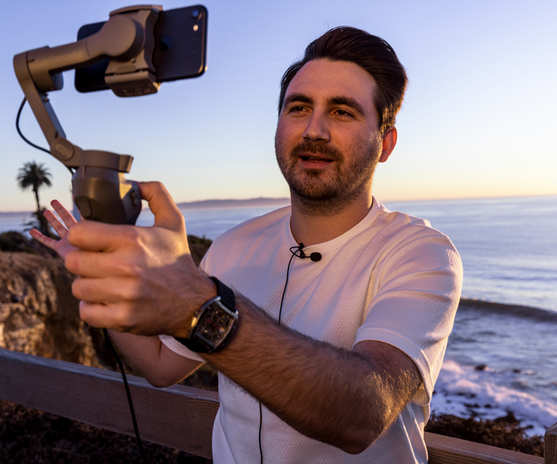 Man filming at with his iPhone at the beach using Apogee ClipMic digital 2